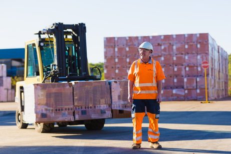 Wienerberger UK employee standing in front of pallet of bricks and forklift