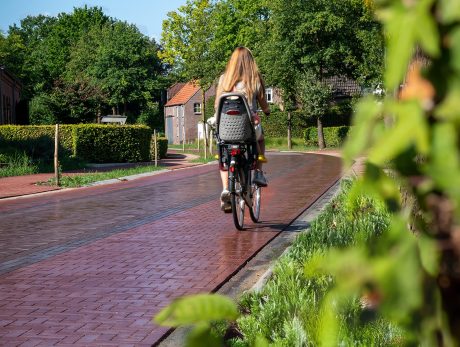 Sfeerbeeld van fietser die op natte straatstenen fietst