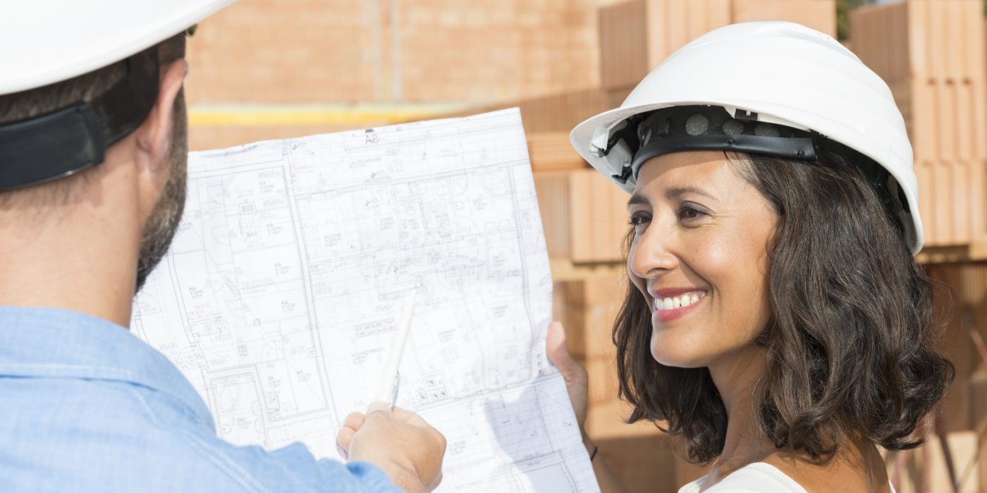 Man with pen pointing at architectural drawing