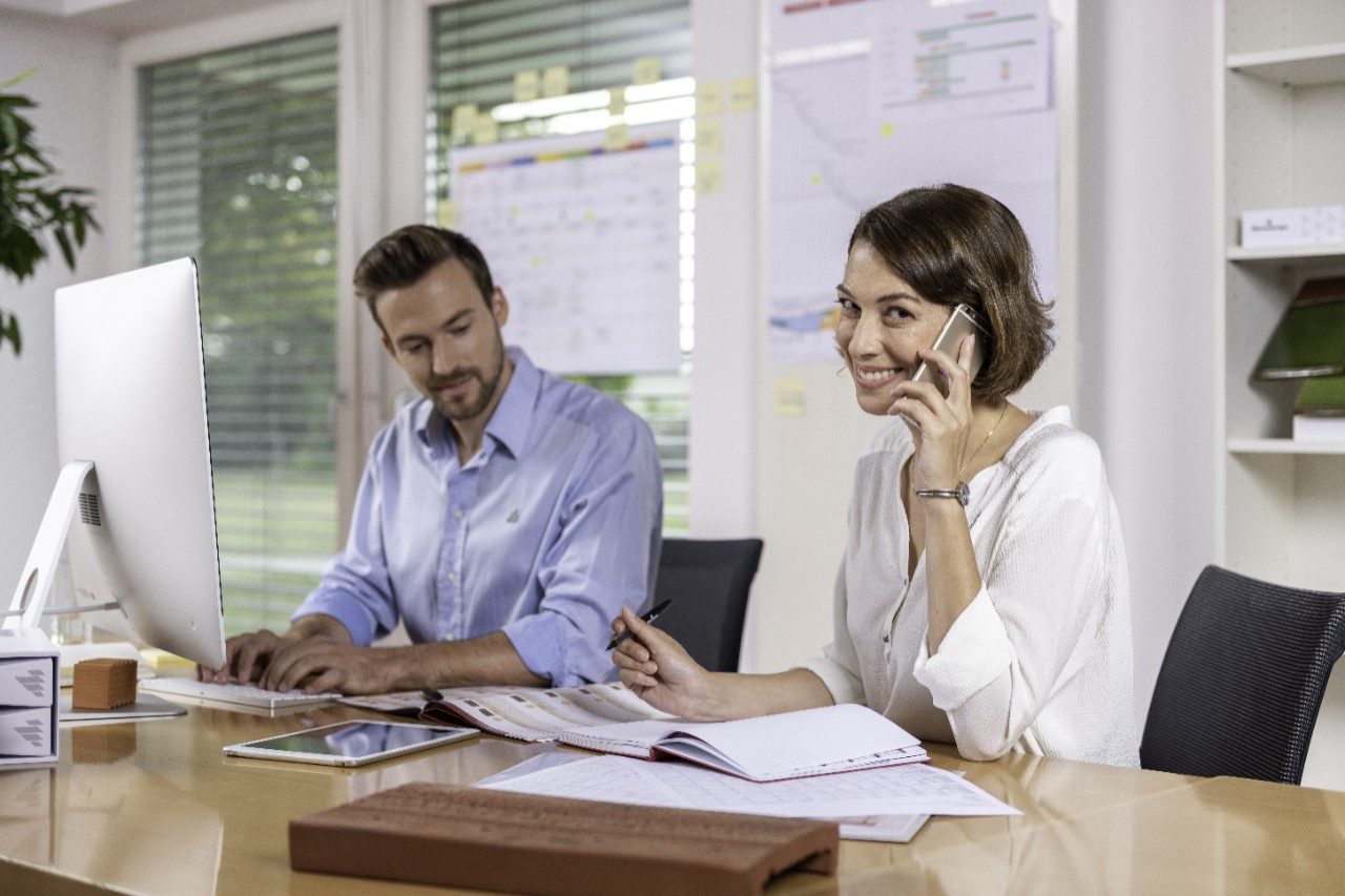 Male and female project manager collaborating in front of computer screen at office
