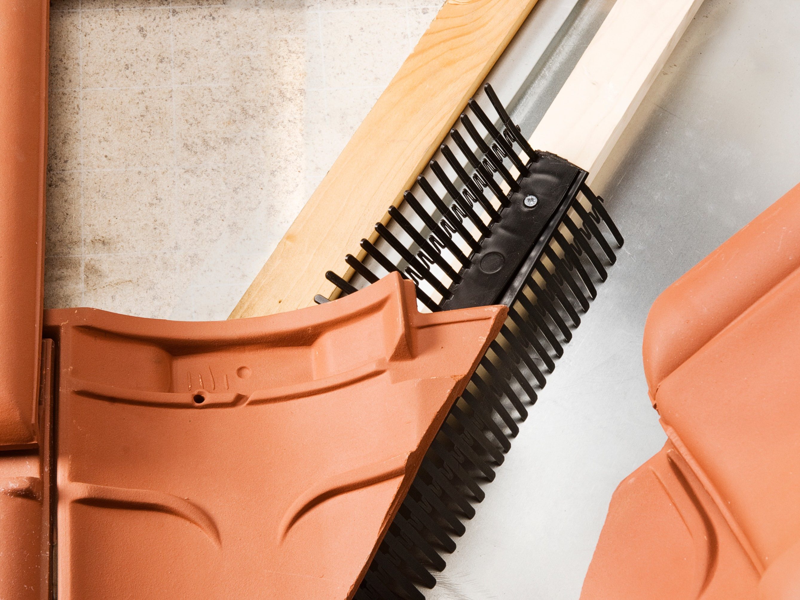 Koramic daktoebehoren: dakvoetafwerking. Een goede dakvoetconstructie is essentieel voor een goede ventilatie van de dakspouw.  Dakvoetprofielen zorgen voor een mooie afwerking en bescherming tegen regen, wind en stuifsneeuw. Vogels, ratten en muizen worden geweerd met het Koramic combidakvoetprofiel, de vogelschroot of de vogel/muisschroot. Niet keramische kwaliteitsproducten voor een technische en esthetische afwerking. Regendicht en ventilatie mogelijk. Technisch en esthetisch dakafwerking bij aansluitdetails, snijlijnen en ventilatieopeningen.