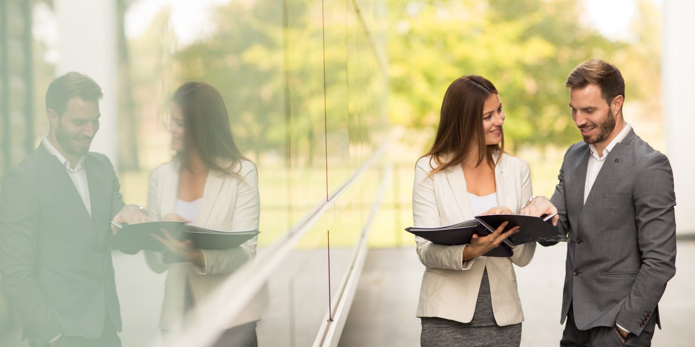 Young business people talking and viewing documents outdoor