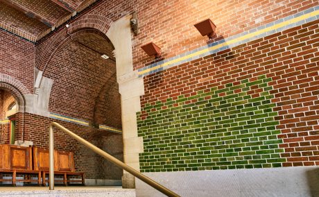 Renovatie de Beurs van Berlage, Damrak, Amsterdam. Architect: Bierman Henket architecten met projectarchitect Henk van Laarhoven. Adviseur: van Bremen Bouwadviseurs, Sanne Mouwen en Wietse den Hartog Opdrachtgever: Beurs van Berlage  Aannemer: N.J. de Nijs te Warmenhuizen. Bouw Matrialen Handel, BMH: Cementbouw Heemstede, Jan Woudhuizen en Niels Bethlehem. Maatwerk Glazuurstenen in verschillende formaten en 15 kleuren die passen bij de oude stenen: 1 kleur geel, 3 kleur blauw, 4 kleuren bruin, 2 kleuren grijs-wit, 3 kleuren wit en 2 kleuren groen (de laatste loodhoudende glazuur): Een deel van het interieur is aangepast rond de receptie (ruimte 0.012), de oude pantry (ruimte 0.06) nu trap naar souterain, twee toiletgroepen (ruimte 0.05) nu  en de tentoonstellingsruimte in de kelder.  Jaar van oplevering: 2017 Rode strengperstenen (uni-rood van Panningen): Nieuwe metselwerkboog rechts van huidige receptie (t.p.v. oude pantry). Rood kolenstook Renova van Wienerberger Bemmel: Vervangen van bestaande deur (Stalen dir met rechte latei) naar nieuwe deur aan achterzijde van de Beurs (Beursstraat). Aanpassing van het metselwerk met segmentboog en inboetwerk. Zie bijgaande foto.